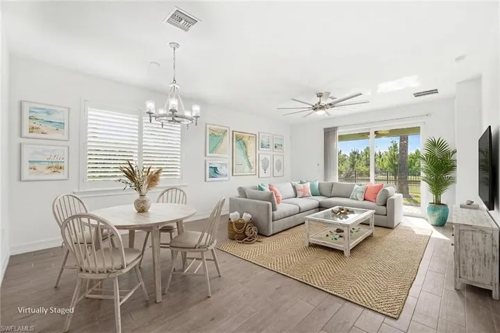 Virtually staged Open-concept living area featuring wood-finish flooring, white walls, and a large sliding glass door