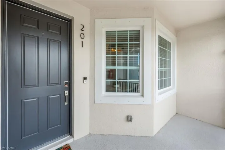 View of exterior entry featuring a porch and stucco siding