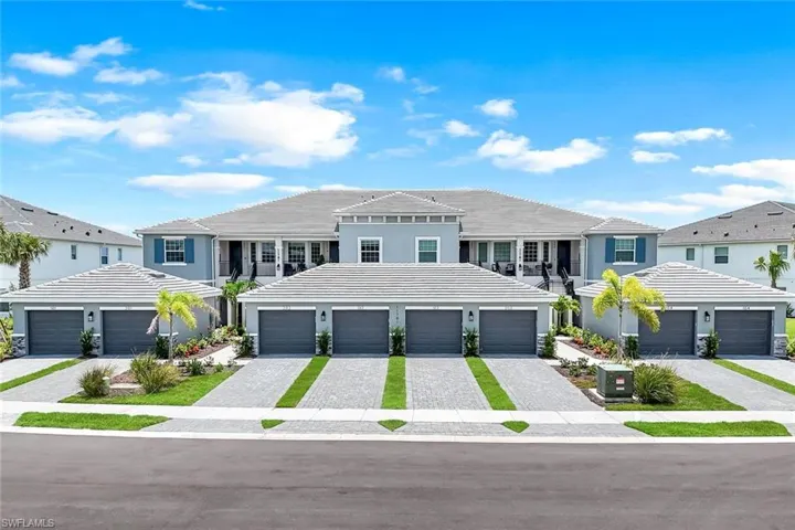 View of front facade featuring decorative driveway, a tiled roof, stucco siding, a residential view, and a garage