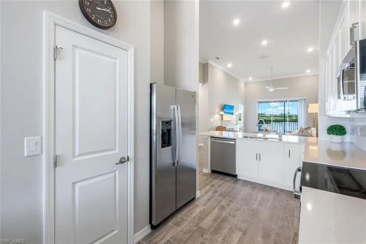 Kitchen featuring stainless steel appliances, light wood-style floors, light countertops, white cabinets, and open floor plan