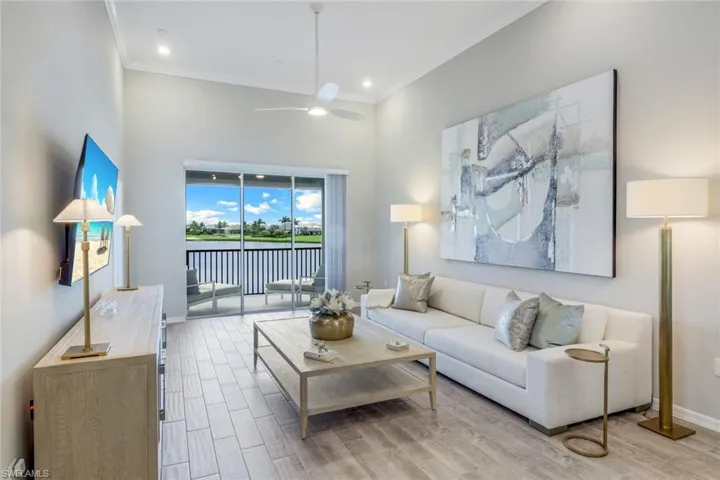 Living area featuring wood finished floors, crown molding, and ceiling fan