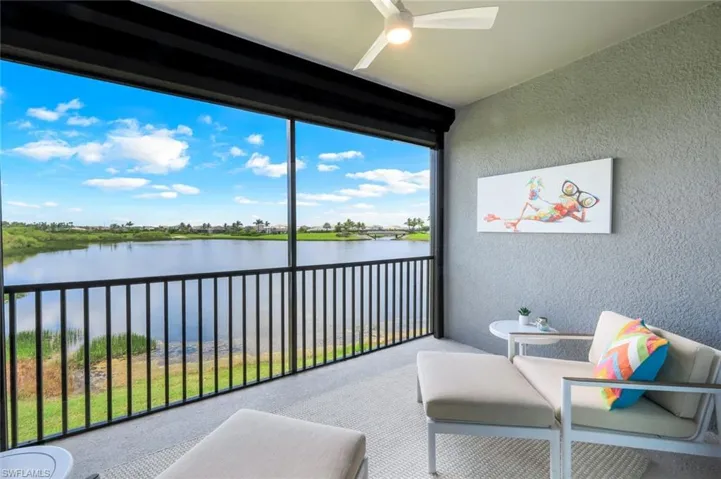 Balcony featuring a water view and ceiling fan