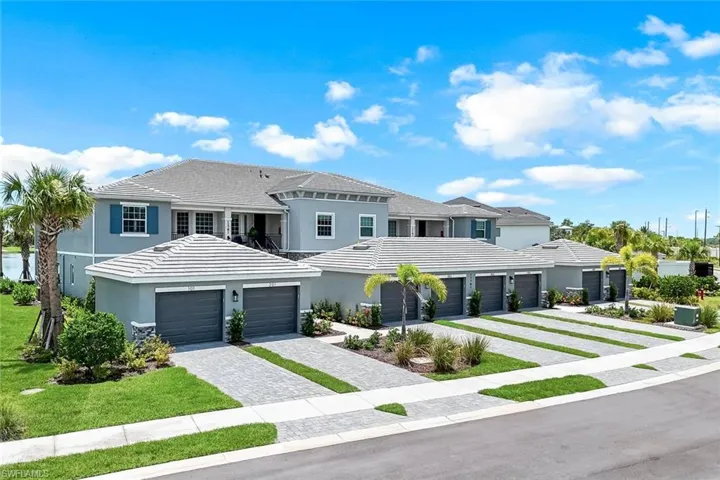 View of front of property with decorative driveway, stucco siding, and a tile roof