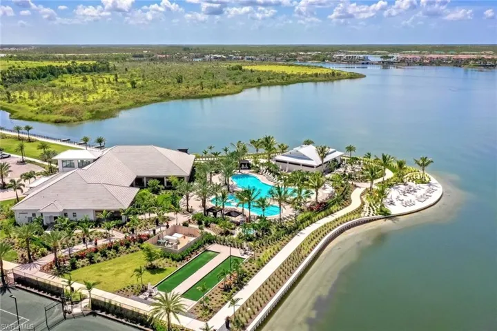 Bird's eye view of a nearby body of water and a pool area