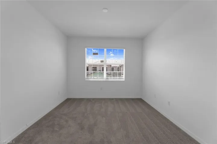 Spare room featuring carpet floors and baseboards