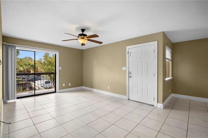 Unfurnished room with ceiling fan, healthy amount of natural light, and light tile patterned floors