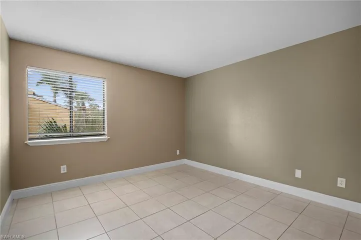 Empty room with baseboards and light tile patterned flooring