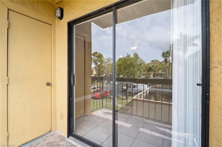 Doorway to outside featuring a textured wall and tile patterned flooring