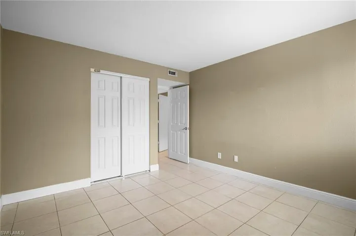 Unfurnished bedroom featuring a closet and light tile patterned floors