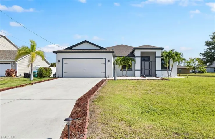 View of front of house featuring a garage and a front yard