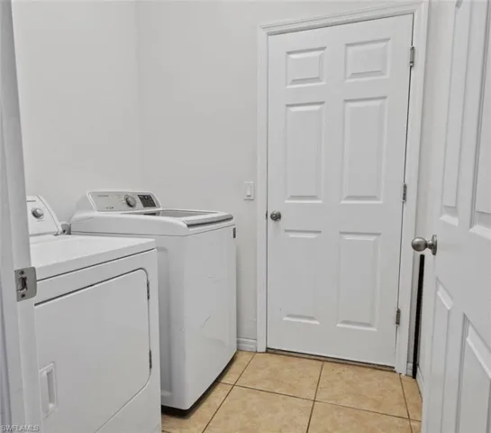 Laundry room featuring independent washer and dryer and light tile floors