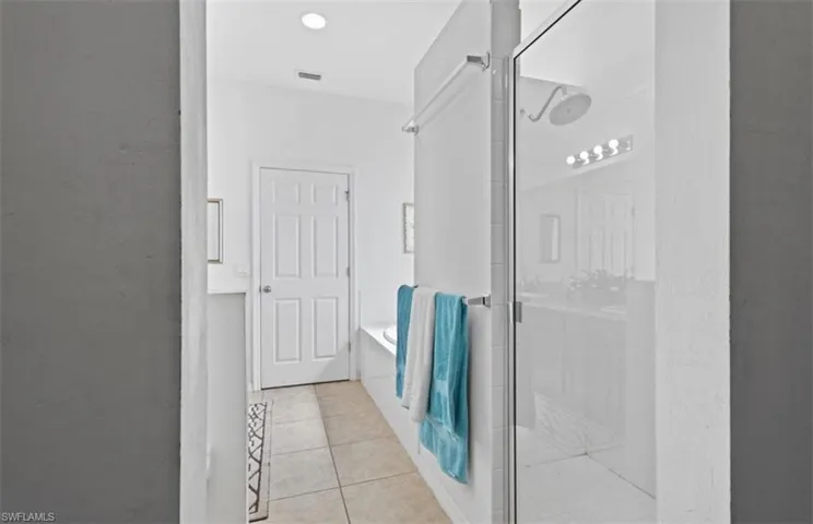 Bathroom featuring tile floors and plus walk in shower