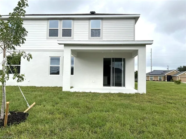 Back of property featuring a patio area, stucco siding, and a yard