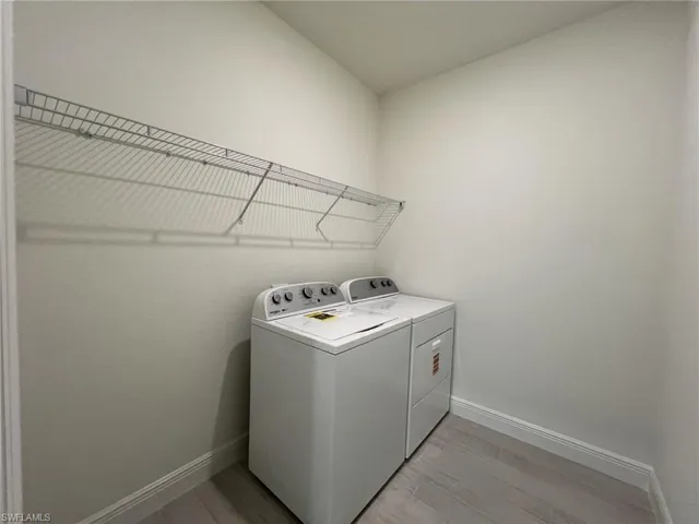 Laundry room with light wood-style floors and washing machine and dryer