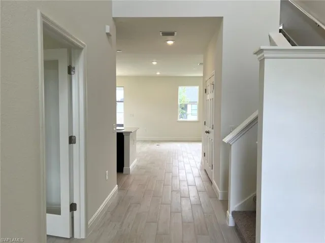 Hall with light wood-style flooring, recessed lighting, and stairway