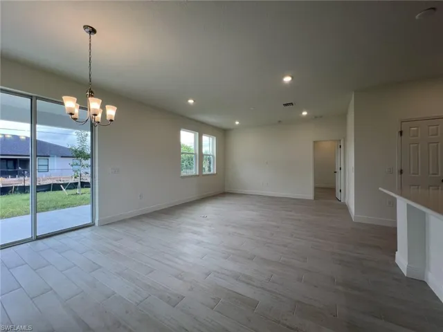 Unfurnished dining area with recessed lighting, light wood finished floors, and a chandelier