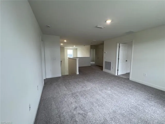 Carpeted spare room featuring baseboards and recessed lighting
