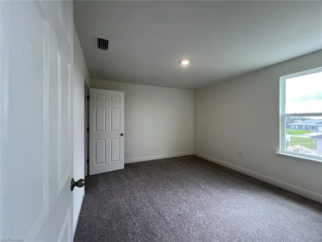 Carpeted empty room with baseboards and recessed lighting