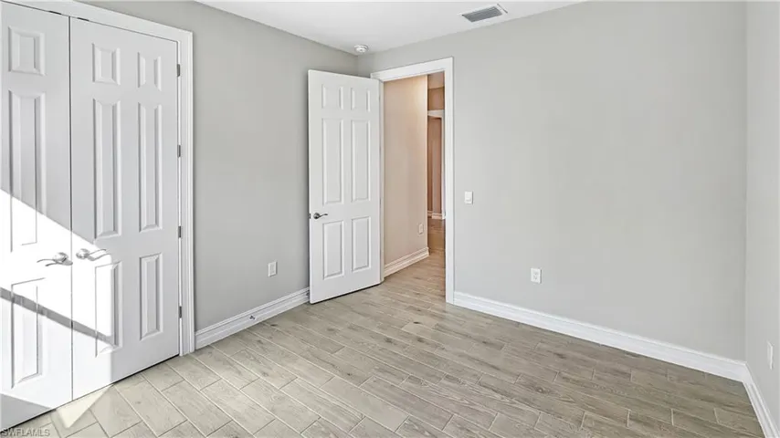 Unfurnished bedroom featuring baseboards, visible vents, and light wood-type flooring