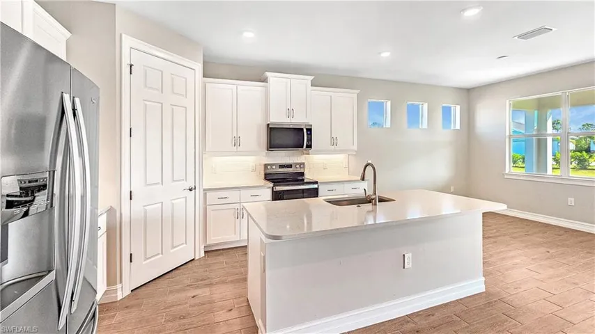 Kitchen featuring visible vents, tasteful backsplash, appliances with stainless steel finishes, a sink, and light wood-style floors
