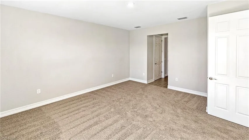 Unfurnished bedroom featuring carpet flooring, baseboards, and visible vents