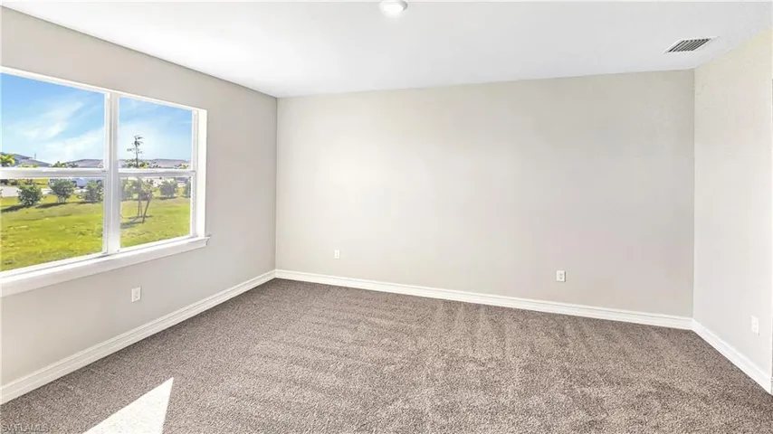Carpeted empty room with baseboards and visible vents
