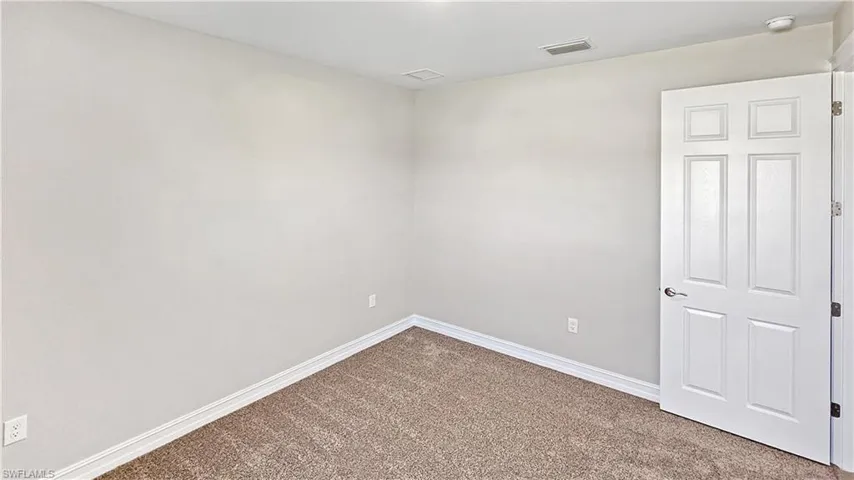 Carpeted empty room featuring baseboards and visible vents