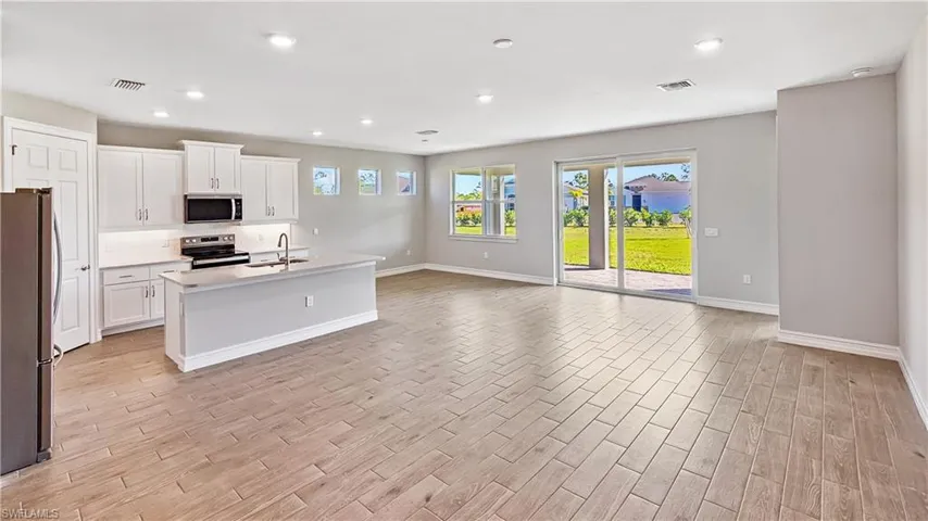 Kitchen with visible vents, a sink, open floor plan, and appliances with stainless steel finishes