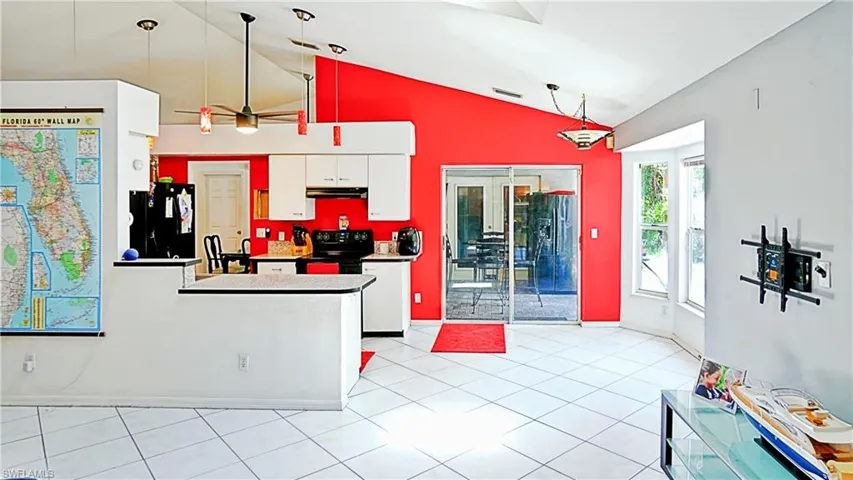 Kitchen with black appliances, lofted ceiling, white cabinetry, a ceiling fan, and under cabinet range hood
