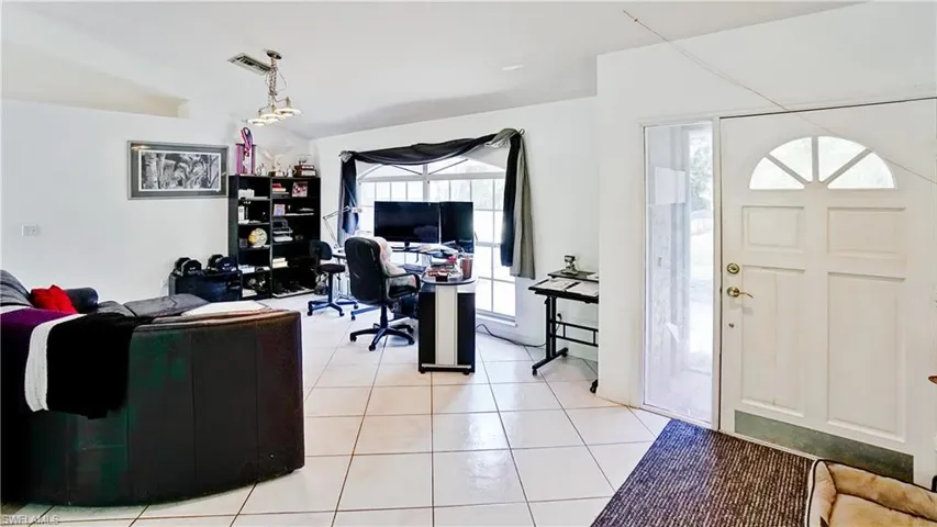 Home office with light tile patterned flooring and healthy amount of natural light