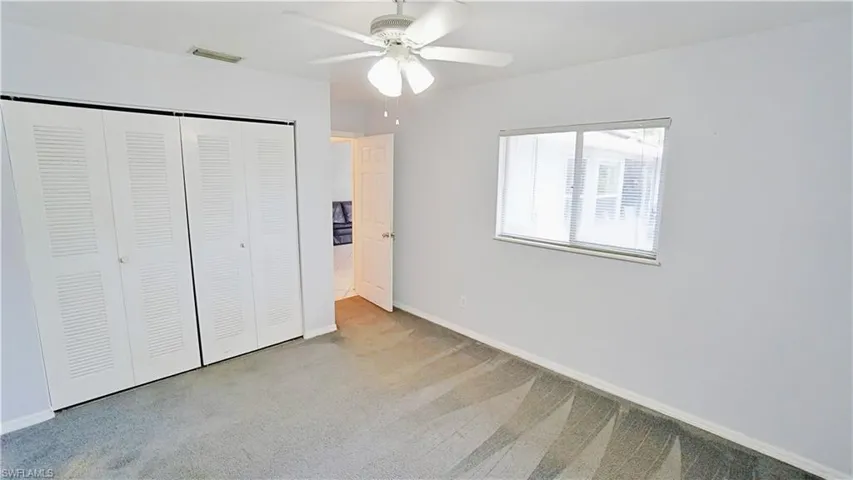 Unfurnished bedroom with a closet, carpet, baseboards, and ceiling fan