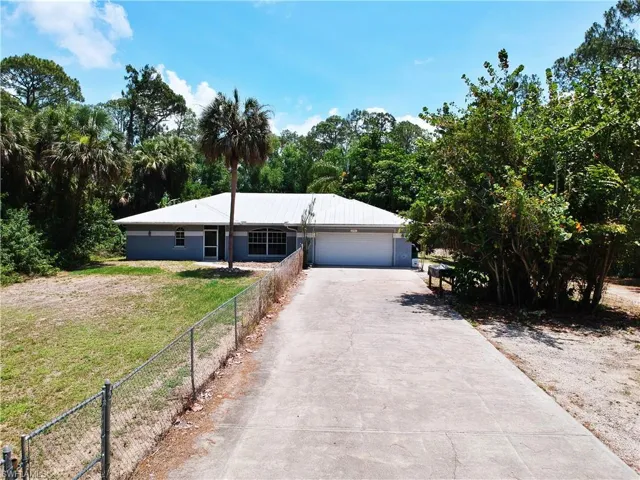 Ranch-style house with asphalt driveway and a garage