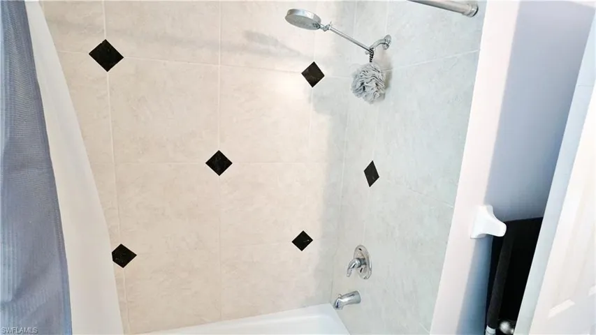 Bathroom with shower / bathtub combination with curtain
