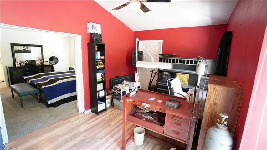 Office with lofted ceiling, a ceiling fan, and wood finished floors