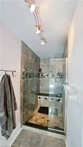 Bathroom with a stall shower and baseboards