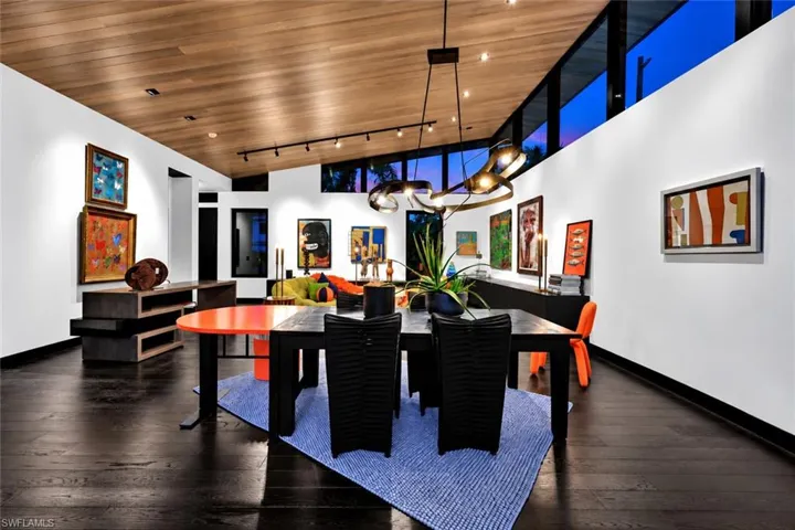 Vaulted wood-paneled ceiling, dark wood-finish flooring, and a continuous band of upper windows