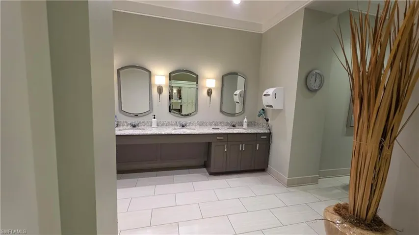 Full bath featuring double vanity and light tile patterned floors