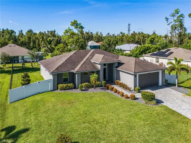 Ranch-style house with a gate, stucco siding, a shingled roof, and decorative driveway