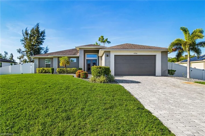 Prairie-style house featuring stucco siding, a garage, and decorative driveway