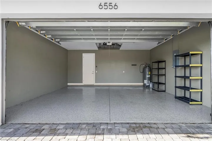 Garage featuring electric panel and water heater