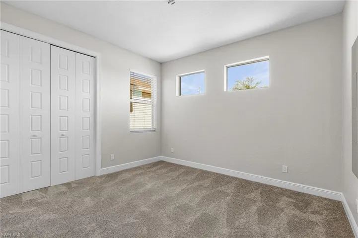 Unfurnished bedroom with carpet and a closet