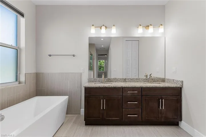 Master Full bath featuring a freestanding tub, double vanity, and a closet