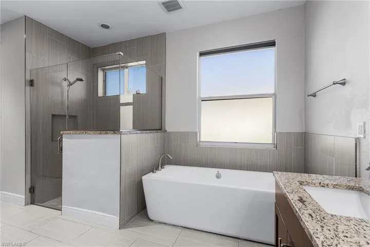 Master Bathroom with a freestanding bath, a stall shower, and vanity