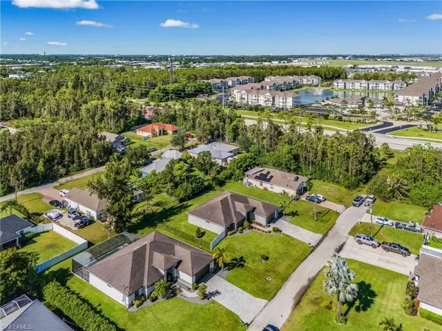Aerial view of property and surrounding area featuring nearby suburban area
