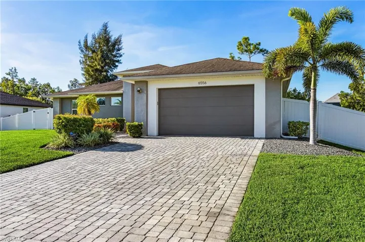 Single story home featuring stucco siding, decorative driveway, an attached garage, and roof with shingles