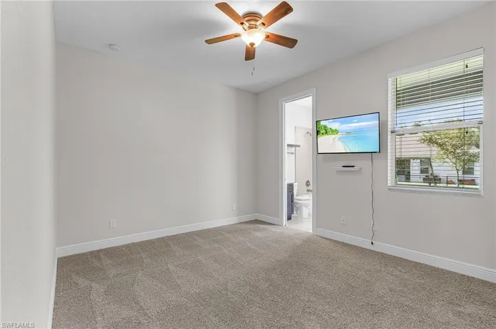 Unfurnished room with light colored carpet and ceiling fan