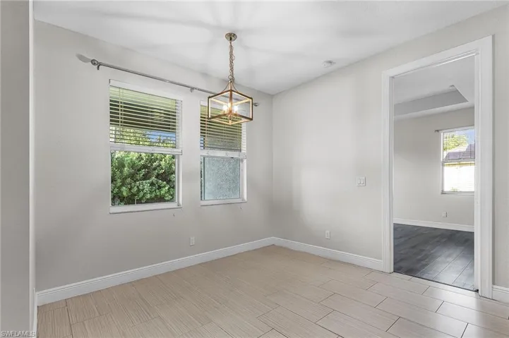 Empty room featuring wood tiled floors and a chandelier