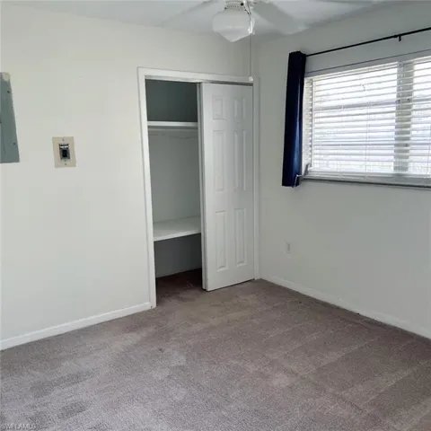 Unfurnished bedroom featuring carpet flooring, electric panel, and a closet
