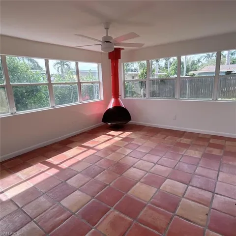 Unfurnished sunroom featuring baseboards and tile patterned floors