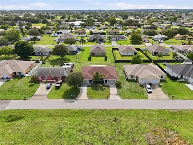 Aerial perspective of a residential neighborhood featuring single-story homes with shingle roofs and integrated garages